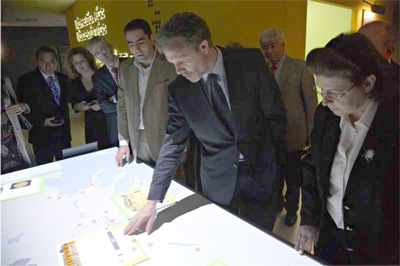 Figure 2: The Minister of Culture and Tourism of Greece explores locations of archaeological interest in Multimodal Diverse Travel. As the users move rectangular pieces of paper on the map, location-based, interactive multimedia content appears on them. 