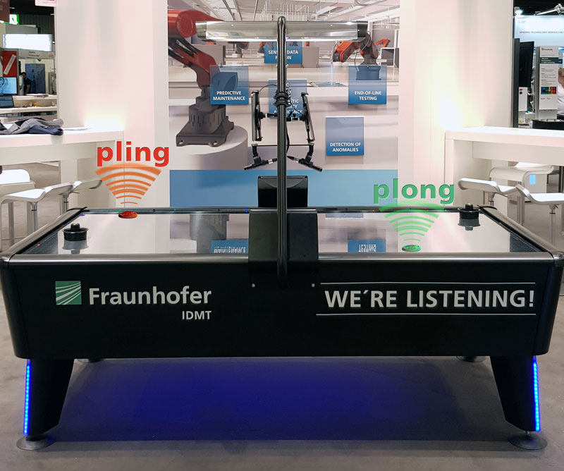 Figure 1: Air hockey table equipped with two measurement microphones recording the puck’s sound (e.g., ‘pling’ and ‘plong’). 