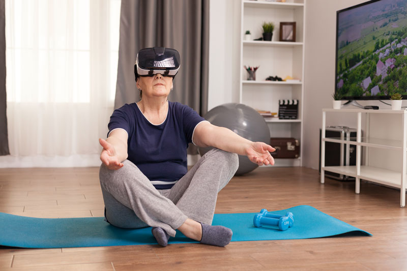 Elderly woman using immersive technologies for training and recreation.