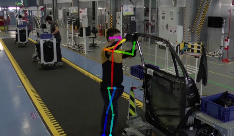 Figure 1: The car-door production line at the CRF workplace, which comprises three assembly workstations. A line worker is assigned to each workstation. The human body pose of a worker is estimated and overlaid (colour-coded skeletal body model). Image courtesy of Stellantis – Centro Ricerche FIAT (CRF) / SPW Research & Innovation department.