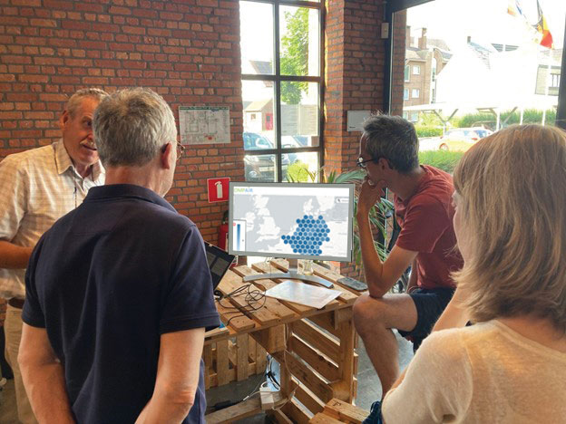 Figure 1: Volunteers discussing collected test-results via dashboard during a School Street Cafe in Herzele.