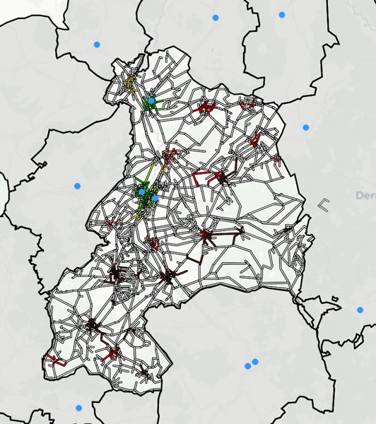 Figure 1: Reachability heat map, which colours each populated area of the city in terms of its distance (on foot and by public transport) to the nearest GP (blue markers). For a distance of less than 15 (15–30, 30–45, 45–60, 60–90, ≥90) minutes to the nearest GP, the areas are coloured green (light green, yellow, pink, red, brown).